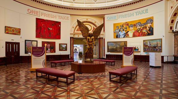 A view of the Round Room with large painting on the wall and a statue of Lucifer by Sir Jacob Epstein.